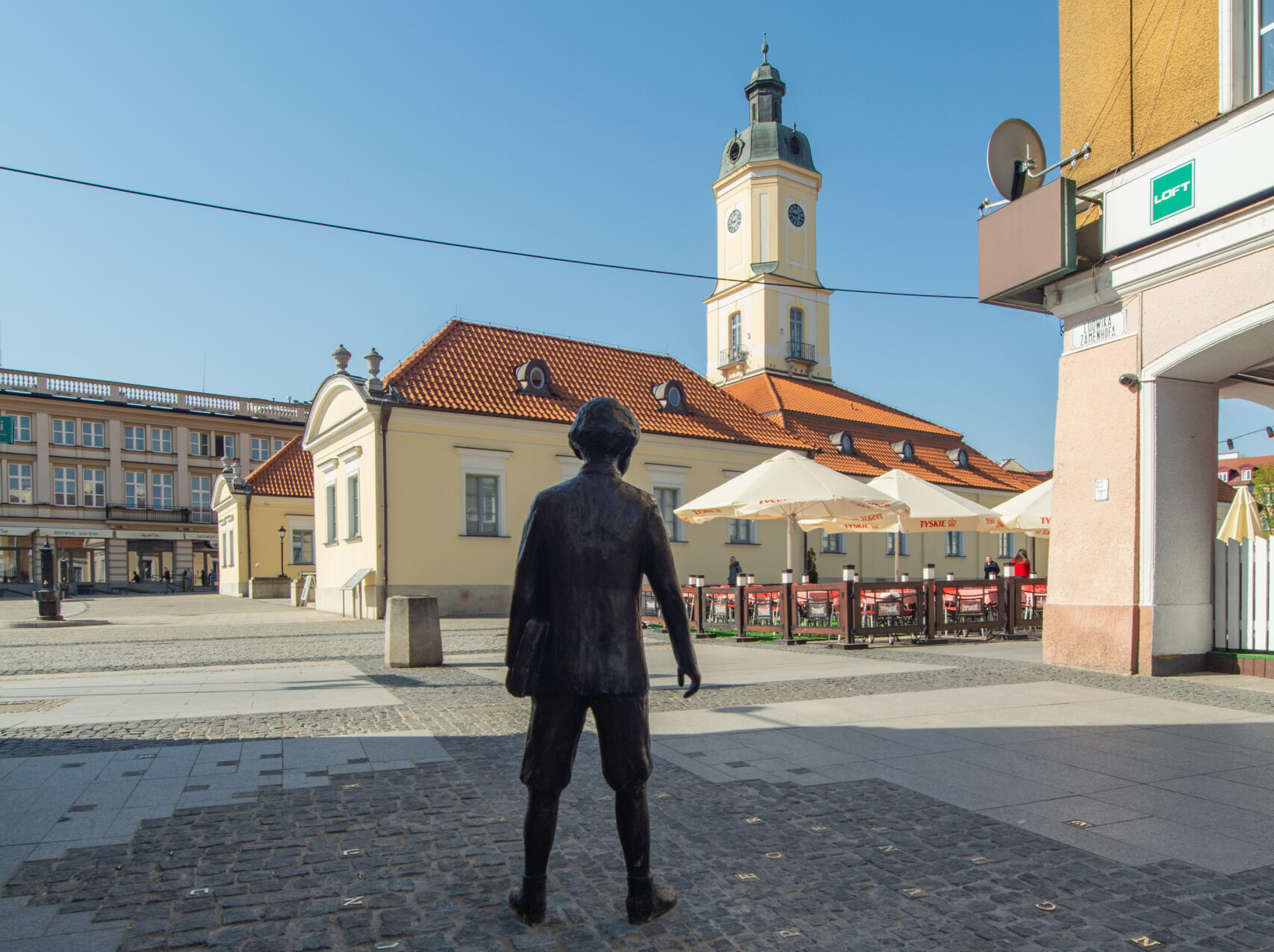 La monumento estas latuna statuo de dekkelkjara Zamenhof de natura alteco. Ĉirkaŭ li, inter pavimeroj, troviĝas disĵetitaj metalaj literoj de la alfabetoj latina, cirila kaj hebrea, al kiuj la persono rigardas.